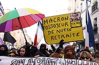 A demonstrator holds a placard which reads "Macron, grave-digger of our retirement" during a rally, called by left-wing La France Insoumise (LFI) party and Youth organizations, to protest against French President's pension reform, in Paris on January 21, 2023. - The pensions plan, presented by French President Emmanuel Macron's government last week, would raise the retirement age for most from 62, to 64 and would increase the years of contributions required for a full pension. The French Interior Ministry put the total number of protesters that marched against France's President's plan to extend the retirement age at 1.2 million, on January 19, 2023, including 80,000 in Paris. (Photo by Thomas SAMSON / AFP)