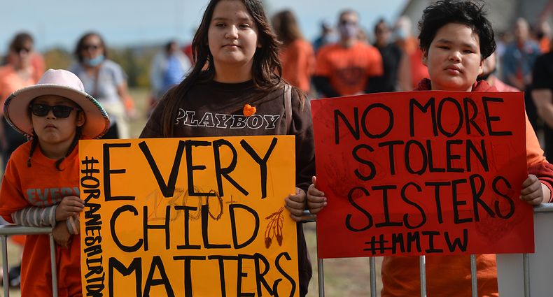 Young members of the First Nations hold placards with words 'Every Child Matter' and 'No More Stolern Sisters' during an outdoor ceremony at Fort Calgaryas, as the City of Calgary commemorates Orange Shirt Day, and observes the first National Day for Truth and Reconciliation (a federal statutory holiday). On Thursday, 30 September 2021, in Fort Calgary, Calgary, Alberta, Canada. (Photo by Artur Widak/NurPhoto via Getty Images)