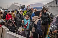 Ukrainian evacuees queue as they wait for further transport at the Medyka border crossing, after they crossed the Ukrainian-Polish border, southeastern Poland, on March 29, 2022, on the 34th day of the Russian invasion of Ukraine. - Ukraine is calling for an "international agreement" to guarantee its security, which would be signed by several guarantor countries, said on March 29, 2022 the Ukrainian chief negotiator after several hours of Russian-Ukrainian talks in Istanbul. (Photo by Angelos Tzortzinis / AFP)