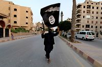 A member loyal to the Islamic State in Iraq and the Levant (ISIL) waves an ISIL flag in Raqqa June 29, 2014. The offshoot of al Qaeda which has captured swathes of territory in Iraq and Syria has declared itself an Islamic "Caliphate" and called on factions worldwide to pledge their allegiance, a statement posted on jihadist websites said on Sunday. The group, previously known as the Islamic State in Iraq and the Levant (ISIL), also known as ISIS, has renamed itself "Islamic State" and proclaimed its leader Abu Bakr al-Baghadi as "Caliph" - the head of the state, the statement said. REUTERS/Stringer (SYRIA - Tags: POLITICS CIVIL UNREST)