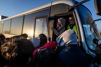 Vários refugiados da Ucrânia reunidos para apanhar um autocarro do posto fronteiriço de Medyka para Przemysl, no leste da Polónia, a 28 de fevereiro de 2022. 