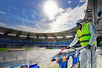 Picture taken on March 4, 2020 shows cleaners wearing a protective suit, as they sanitise the seats of the San Paolo stadium in Naples. - Italy ordered on March 4 that all major sporting events be held behind closed doors until April 3 as the country grapples with the deadly coronavirus outbreak. The government decision was announced moments after health officials said the death toll from COVID-19 had jumped to 107 and the number of cases had passed 3,000. (Photo by CIRO FUSCO / ANSA / AFP) / - Italy OUT