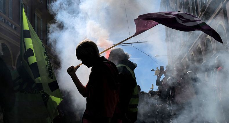 TOPSHOT - A protester holds an union flag, during a demonstration after the government pushed a pensions reform through parliament without a vote, using the article 49.3 of the constitution, in Nice, southern France, on March 28, 2023. - France faces another day of strikes and protests nearly two weeks after the president bypassed parliament to pass a pensions overhaul that is sparking turmoil in the country, with unions vowing no let-up in mass protests to get the government to back down. The day of action is the tenth such mobilisation since protests started in mid-January against the law, which includes raising the retirement age from 62 to 64. (Photo by Valery HACHE / AFP)