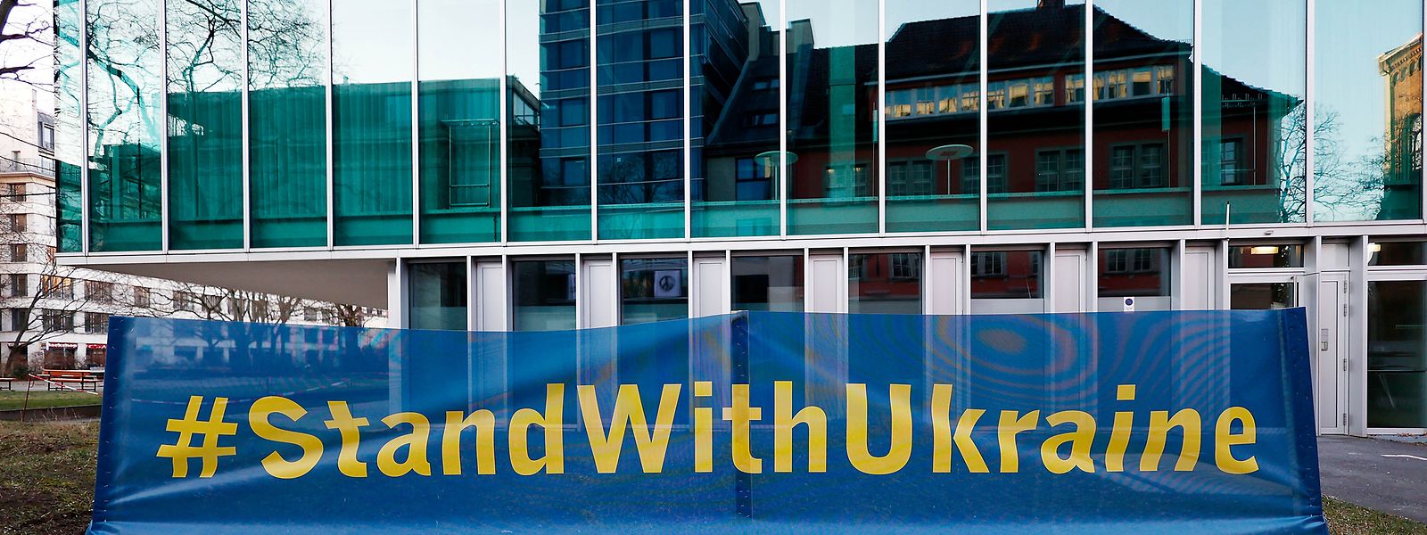 Gegenüber einer Botschaft der Ukraine haben Menschen ein Banner mit der Aufschrift „#StandWithUkraine“ aufgestellt, um ihre Solidarität und Anteilnahme für die Ukraine zu zeigen.