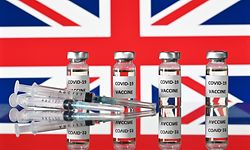 (FILES) This file illustration photo taken on November 17, 2020 shows vials with Covid-19 Vaccine stickers attached, and syringes, with a national flag of the United Kingdom, the Union flag. Drugs company AstraZeneca and British Prime Minister Boris Johnson on January 28, 2021 defended the effectiveness of its Covid-19 vaccine after regulators in Germany said it should not be given to over 65s. (Photo by JUSTIN TALLIS / AFP)