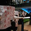 Protesters hold up a sign (L) and sheets of blank paper at the University of Hong Kong campus in solidarity with demonstrations in mainland China against strict Covid restrictions and demanding for greater freedoms, in Hong Kong, on November 29, 2022. (Photo by Yan ZHAO / AFP)