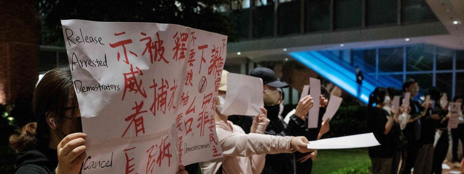 Demonstranten halten auf dem Campus der Universität Hongkong ein Schild und ein leeres Blatt Papier in die Höhe, um sich mit den Demonstrationen in Festlandchina zu solidarisieren.