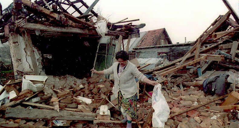 ARCHIV - 09.04.1995, Bosnien-Herzegowina, Sarajevo: Die bosnische Muslima Ziba Suba sucht in den Trümmern ihres bei einem serbischen Angriff zerstörten Wohnhauses nach den letzten Habseligkeiten. Der Bosnienkrieg (1992-1995) ist der blutigste der Konflikte nach dem Zerfall des Vielvölkerstaates Jugoslawien in den 1990er Jahren. Die Zahl der Todesopfer wird mit 100 000 beziffert, Hunderttausende wurden verletzt. Fast jeder zweite der 4,3 Millionen Einwohner - 1,8 Millionen - verlor seine Heimat. (zu dpa «Bosniens unfertiger Frieden - Das Abkommen von Dayton wird 25») Foto: Anja Niedringhaus/epa/dpa +++ dpa-Bildfunk +++