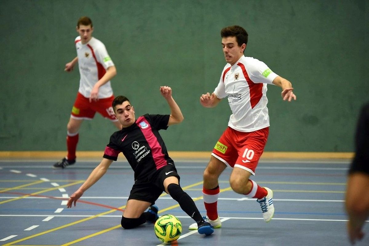Flavio Ribeiro (n°10) de Feulen (en blanc) tente d'éviter l'intervention d'Edgar Rodrigues, du Futsal Nordstad