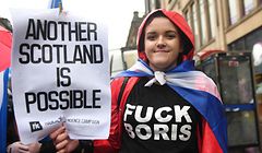 A pro-independence protester holds up a placard as she joins a march organised by the grassroots organistaion All Under One Banner calling for Scottish independence in Glasgow on January 11, 2020. - Thousands of independence supporters are expected the march through the streets of Glasgow, despite a rally that was planned to conclude the event being cancelled after Met Office warnings of high winds. (Photo by ANDY BUCHANAN / AFP)