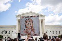TOPSHOT - A person holds a sign in support of Swedish environment activist Greta Thunberg (not pictured) as people gather in front of the US Supreme Court (background) to support the children's climate lawsuit against the US, in Washington, DC, on September 18, 2019. (Photo by Alastair Pike / AFP)