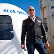 Billionaire Jeff Bezos in front of a Blue Origin space capsule.