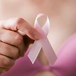 Breast cancer awareness. Woman in pink bra holding a pink ribbon, a reminder of the importance of breast examination in healthcare and medicine, to maintain and sustain a cancer-free, healthy lifestyle.