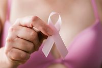 Breast cancer awareness. Woman in pink bra holding a pink ribbon, a reminder of the importance of breast examination in healthcare and medicine, to maintain and sustain a cancer-free, healthy lifestyle.