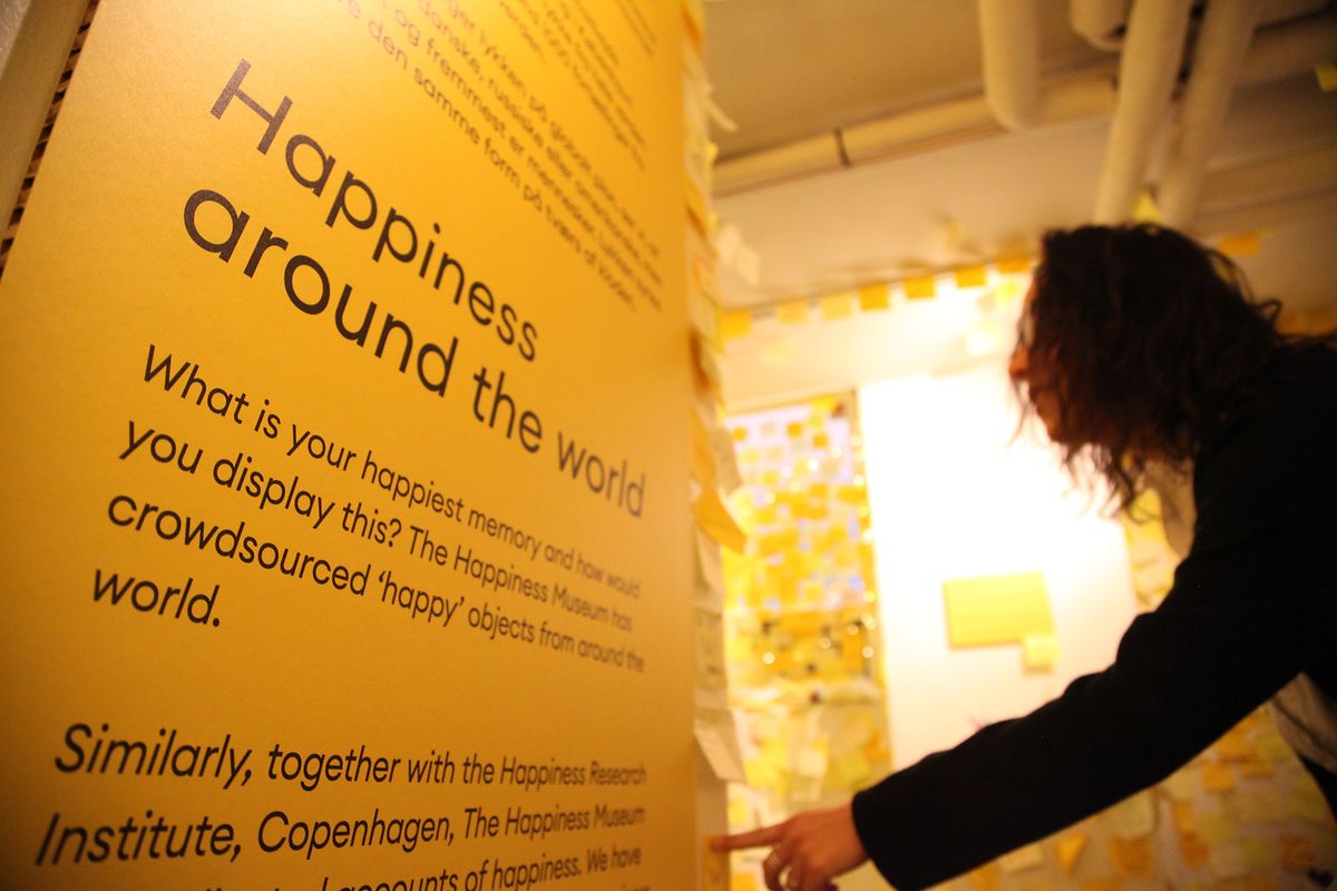 Catarina Lachmund vom Glücksforschungsinstitut Kopenhagen schaut sich im Glücksmuseum die Klebezettel mit persönlichen Glücksrezepten und Wünschen an. 