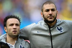 (FILES) This file photo taken on June 30, 2014 shows France's midfielder Mathieu Valbuena (L) and forward Karim Benzema listening to the French national anthem before the round of 16 football match between France and Nigeria at the Mane Garrincha National Stadium in Brasilia during the 2014 FIFA World Cup. Versailles' court will deliberate on March 4, 2016 on whether or not to lift a judicial review against Karim Benzema prohibiting any contact with the victim, his team-mate Valbuena in the sextape case. / AFP / FRANCK FIFE
