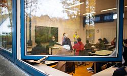 26.10.2020, Nordrhein-Westfalen, Gütersloh: Ein Kehrblech steckt zwischen Fensterrahmen und Fensterbank und verhindert somit das Zufallen des Fensters, beim Schulbeginn in der Freiherr-vom-Stein-Realschule. Ein wichtiges Element in den Hygienekonzepten der Schulen zum Schutz vor Corona ist das intensive Lüften der Klassenräume. Viele Schüler und Eltern fürchten, dass es in den kommenden Wochen und Monaten in den Klassenräumen kalt werden könnte. Alle 20 Minuten Stoßlüften lautet die Vorgabe vom Schulministerium. Eine Maßnahme, die dafür sorgen soll, dass die Aerosol-Konzentration und damit das Corona-Risiko nicht zu stark ansteigen. Foto: Guido Kirchner/dpa +++ dpa-Bildfunk +++