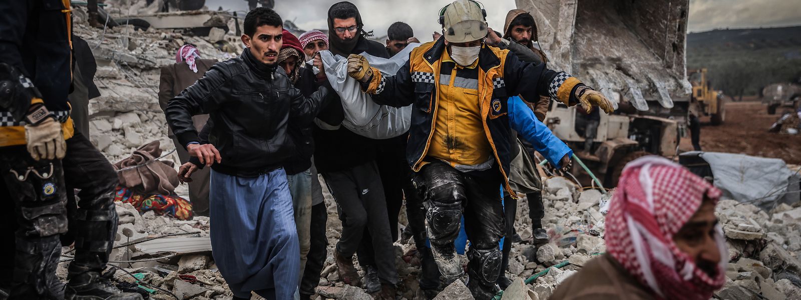Harem: Zivilisten und Mitglieder des syrischen Zivilschutzes führen Such- und Rettungsmaßnahmen in den Trümmern eines zerstörten Gebäudes durch. 