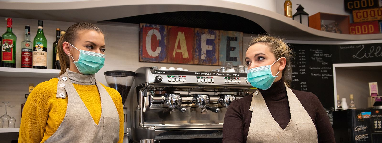 Italien, Bologna: Die Mitarbeiterinnen eines Cafés servieren mit Mundschutz Kaffee. Das wird demnächst nicht mehr möglich sein.