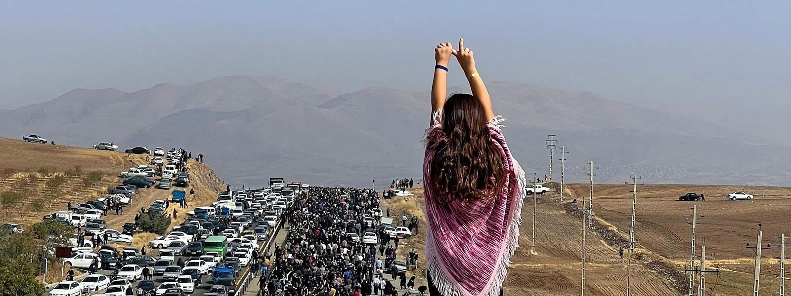 Uma das imagens mais marcantes do protesto, uma jovem mostra o cabelo numa fila de manifestantes que se deslocam para o cemitério Aichi, onde Mahsa Amini foi enterrada.