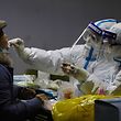 A resident undergoes a Covid-19 coronavirus test at the basement of a residential compound  as part of a mass testing programme following new cases of the virus emerging in Shijiazhuang, in central China's Hebei province on January 12, 2021. (Photo by STR / AFP) / China OUT