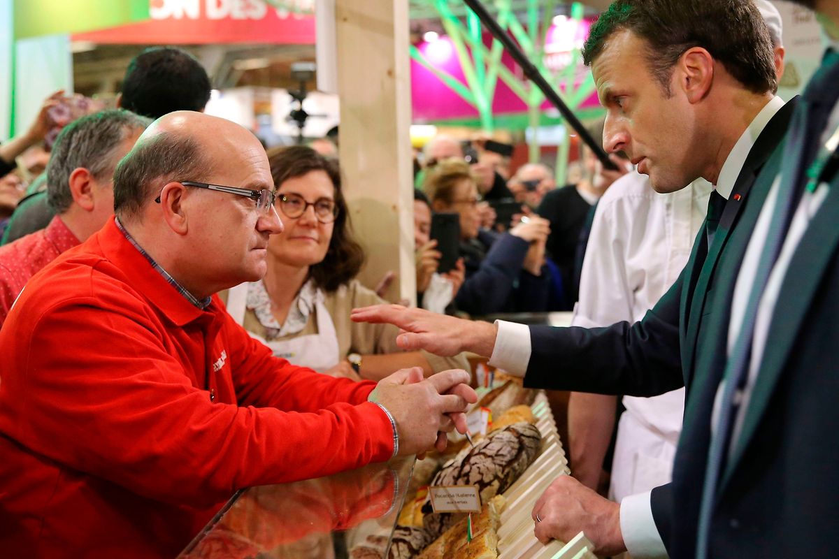 French President Emmanuel Macron speaks with a baker as he visits the 55th International Agriculture Fair in Paris on 24 February 2018 ( AFP)