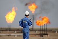 (FILES) In this file photo taken on October 30, 2015, an Iraqi oil worker speaks on a radio transciever at an oil refinery in the southern town Nasiriyah. - As crude prices plunge, Iraq's oil sector is facing a triple threat that has slashed revenues, risks denting production and may spell trouble for future exports. (Photo by HAIDAR MOHAMMED ALI / AFP)