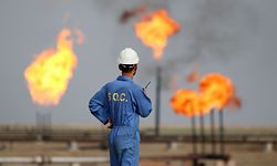 (FILES) In this file photo taken on October 30, 2015, an Iraqi oil worker speaks on a radio transciever at an oil refinery in the southern town Nasiriyah. - As crude prices plunge, Iraq's oil sector is facing a triple threat that has slashed revenues, risks denting production and may spell trouble for future exports. (Photo by HAIDAR MOHAMMED ALI / AFP)