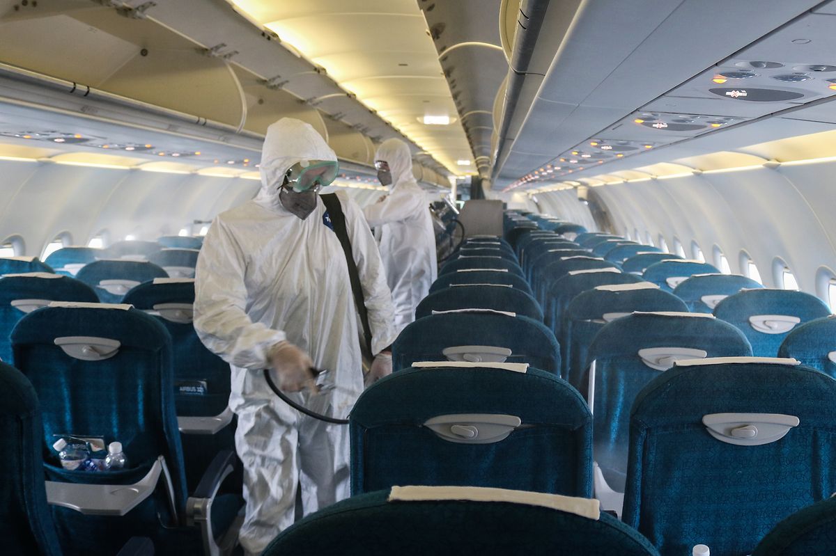 Mitarbeiter des "Center for Disease Control and Prevention (CDC)" in Hanoi versprühen in einem Flugzeug am internationalen Flughafen Noi Bai Desinfektionsmittel. 
