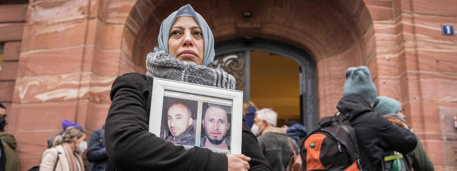 Ativista síria Yasmen Almashan com fotografias de vítimas do regime sírio, enquanto esperam à porta do tribunal onde Anwar Raslan está a ser julgado em Koblenz, na Alemanha. 