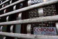 (FILES) In this file photo taken on March 11, 2021 a sign reading 'Corona - message to all...' is seen behind the closed shutter of a shop in Berlin. - Germany is poised to tighten a partial lockdown into April to halt an exponential spread of the coronavirus driven by variants. Europe's biggest economy had progressively began easing restrictions, first reopening schools in late February, before allowing some shops to resume business in March. But hopes for indoor dining, cultural and leisure facilities to follow suit will now have to be delayed, as a third wave of the virus has sent infections numbers rising again. (Photo by Tobias Schwarz / AFP)