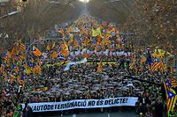 People hold a giant banner reading "Autodetermination is not a crime" during a protest against the trial of former Catalan separatist leaders in Barcelona on February 16, 2019. - Twelve Catalan separatist politicians and activists face years behind bars if they are convicted of rebellion or other charges for pushing an independence referendum in October 2017, in defiance of a court ban, and a brief declaration of independence. (Photo by LLUIS GENE / AFP)
