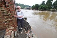 A local resident exits his house facing the destroyed and flooded road in Trooz, near Liege, on July 16, 2021. - The death toll from devastating floods in Europe soared to at least 126 on July 16, 2021, most in western Germany where emergency responders were frantically searching for missing people. In Belgium, the government confirmed the death toll had jumped to 20 - earlier reports had said 23 dead - with more than 21,000 people left without electricity in one region. (Photo by JOHN THYS / AFP)