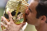 (FILES) In this file photo taken on July 16, 2017 Switzerland's Roger Federer kisses the winner's trophy after beating Croatia's Marin Cilic in their men's singles final match, during the presentation on the last day of the 2017 Wimbledon Championships at The All England Lawn Tennis Club in Wimbledon, southwest London. - Roger Federer announces his retirement in a statement on September 15, 2022. (Photo by Glyn KIRK / AFP) / RESTRICTED TO EDITORIAL USE