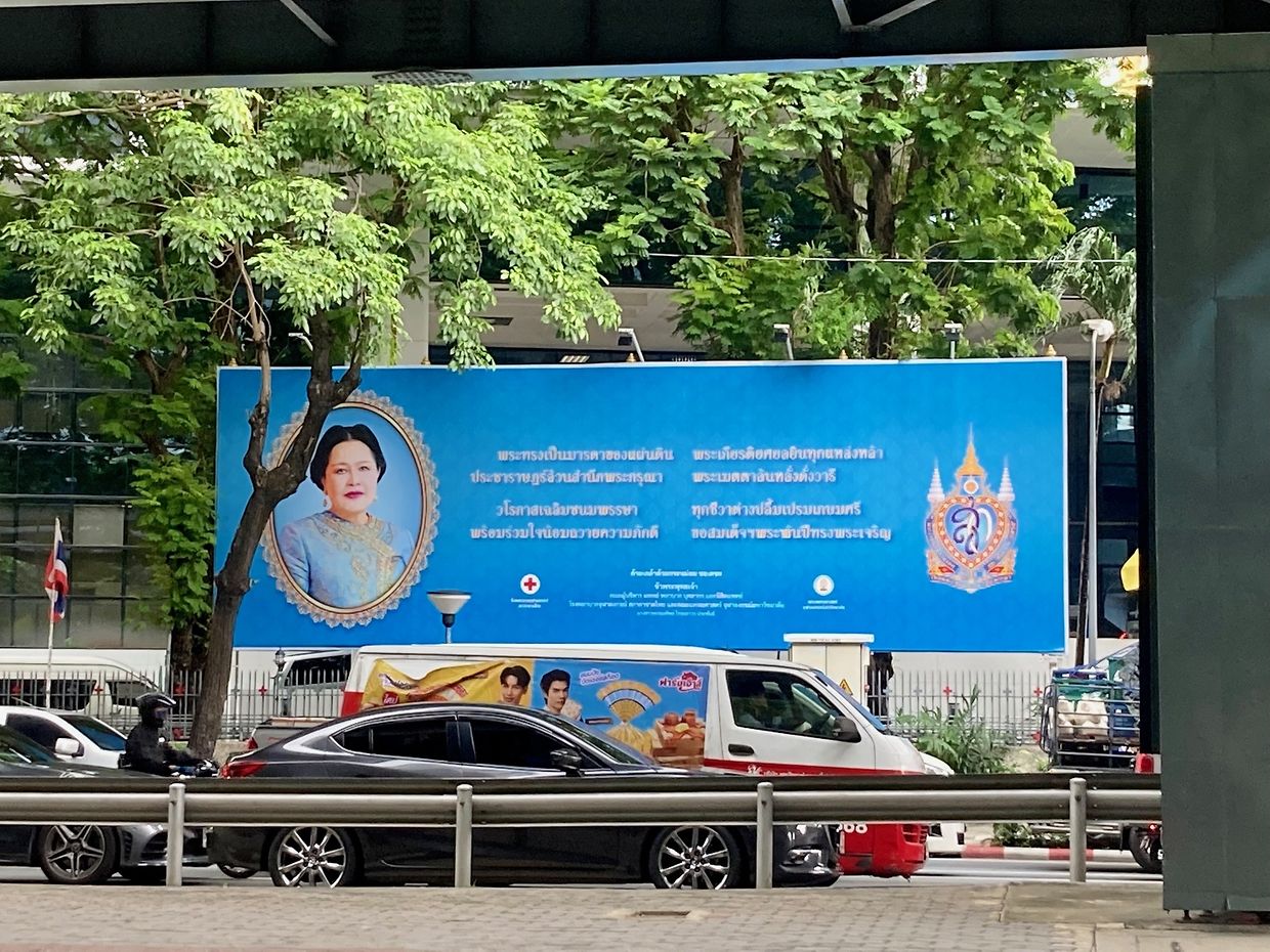 Ein Plakat vor einem Krankenhaus im Zentrum von Bangkok, auf dem Ex-Königin Sirikit für ihre Dienste für das thailändische Rote Kreuz gedankt wird.