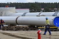 (FILES) In this file photo taken on March 26, 2019 workers walk at the construction site of the so-called Nord Stream 2 gas pipeline in Lubmin, northeastern Germany. - German Chancellor Angela Merkel welcomed on July 22, 2021 a compromise struck with the United States over a controversial Russian gas pipeline project, but said "differences" remained. Merkel said the agreement on Nord Stream 2, which threatens sanctions on Russia should it use energy as a weapon against Ukraine, was a "good step, that showed the willingness to compromise on both sides". But, she added, "differences remain". The pipeline has long been a sore point between Washington and Berlin, but the agreement announced on July 21, 2021 aims to draw a line under the row. (Photo by Tobias SCHWARZ / AFP)