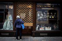 A woman stands in front of the closed patisserie in Bratislava downtown on November 25, 2021. - Slovakia declared a two-week lockdown following a spike in COVID-19 cases with the country�s seven-day average of cases rise above 10,000. (Photo by VLADIMIR SIMICEK / AFP)