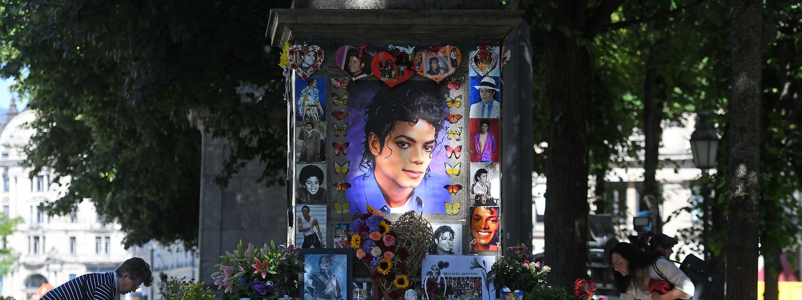 Zwei Frauen schmücken das Michael Jackson-Denkmal am Promenadeplatz vor der Fan-Gedenkfeier zum zehnten Todestag von Michael Jackson. Eigentlich ist das Denkmal Orlando di Lasso gewidmet; aber es steht gegenüber dem Hotel, dass Jackson nutzte, wenn er in München zu Gast war.