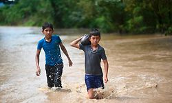 November 2020: Zwei Jungen waten durch überschwemmtes Land nördlich von Guatemala City nach dem Hurrikan Eta. 1,2 Millionen Kinder in der Region sind von der Katastrophe betroffen, schätzt die Unicef.