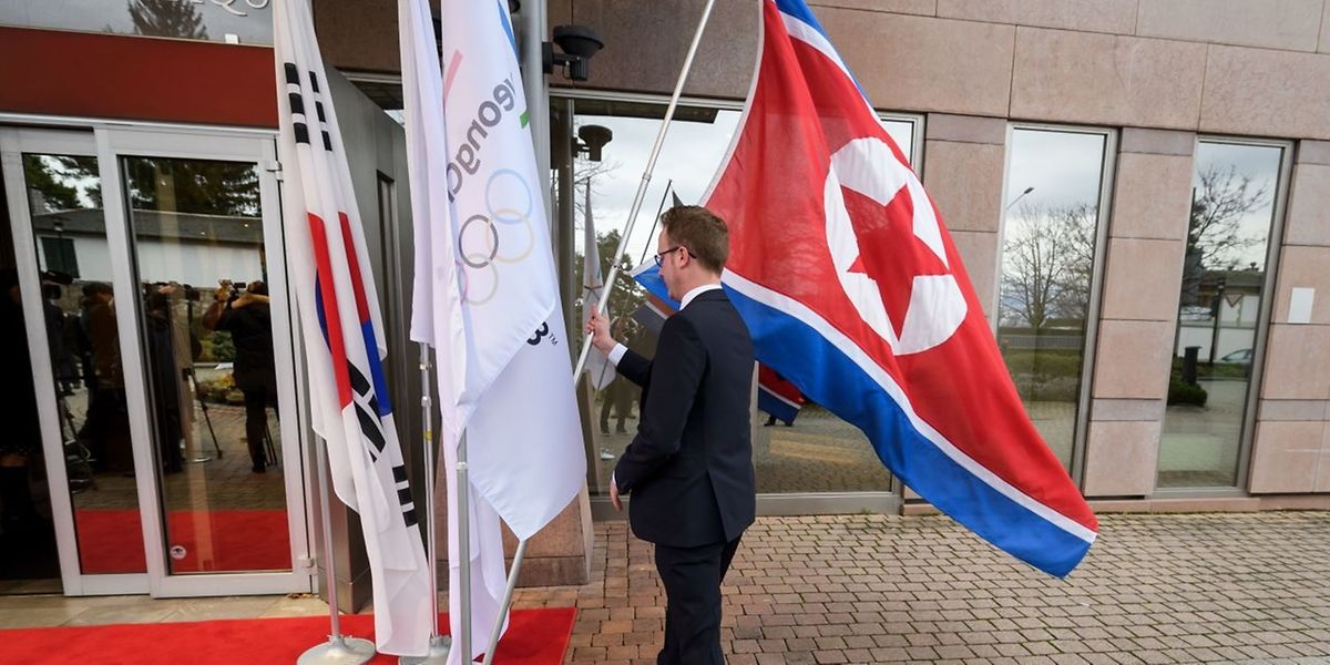 Eine nordkoreanische Flagge wird von einem Mitarbeiter des olympischen Komitees aufgestellt. 