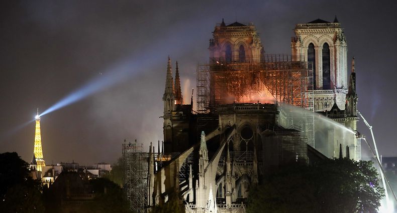(FILES) In this file photo taken on April 15, 2019 firefighters douse flames billowing from the roof at Notre-Dame Cathedral in Paris. - One year ago, on April 15, 2019, a fire erupted in Notre-Dame Cathedral in Paris, partly destroying the nearly millenium old building and its precious artworks visited by millions of people a year. (Photo by LUDOVIC MARIN / AFP)