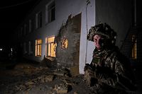 TOPSHOT - An Ukrainian soldier stands guard near debris after the reported shelling of a kindergarten in the settlement of Stanytsia Luhanska, Ukraine, on February 17, 2022. - U.S. Defence Secretary Lloyd Austin warned on February 17, 2022, of a provocation by Moscow to justify military intervention in Ukraine after "disturbing" reports of mutual accusations of bombing between the Ukrainian military and pro-Russian separatists. (Photo by Aris Messinis / AFP)