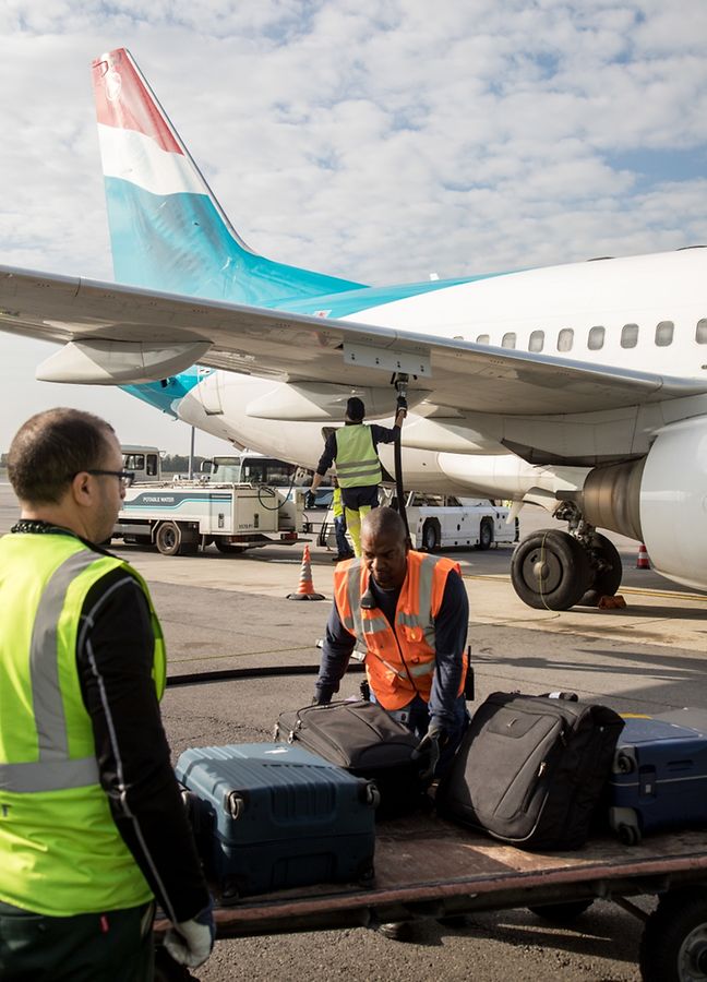 Während die einen Gepäck stapeln, kümmert sich ein anderer um das Betanken des Flugzeugs.
