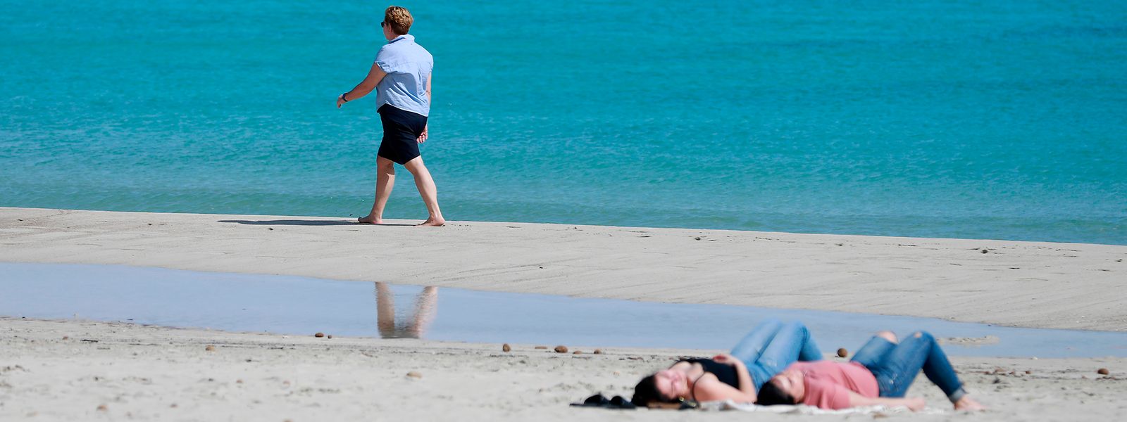 Eine Frau spaziert am Strand von Cala Millor auf Mallorca. Ungewöhnlich hohe Temperaturen für diese Jahreszeit werden für dieses Wochenende auf Mallorca erwartet.  