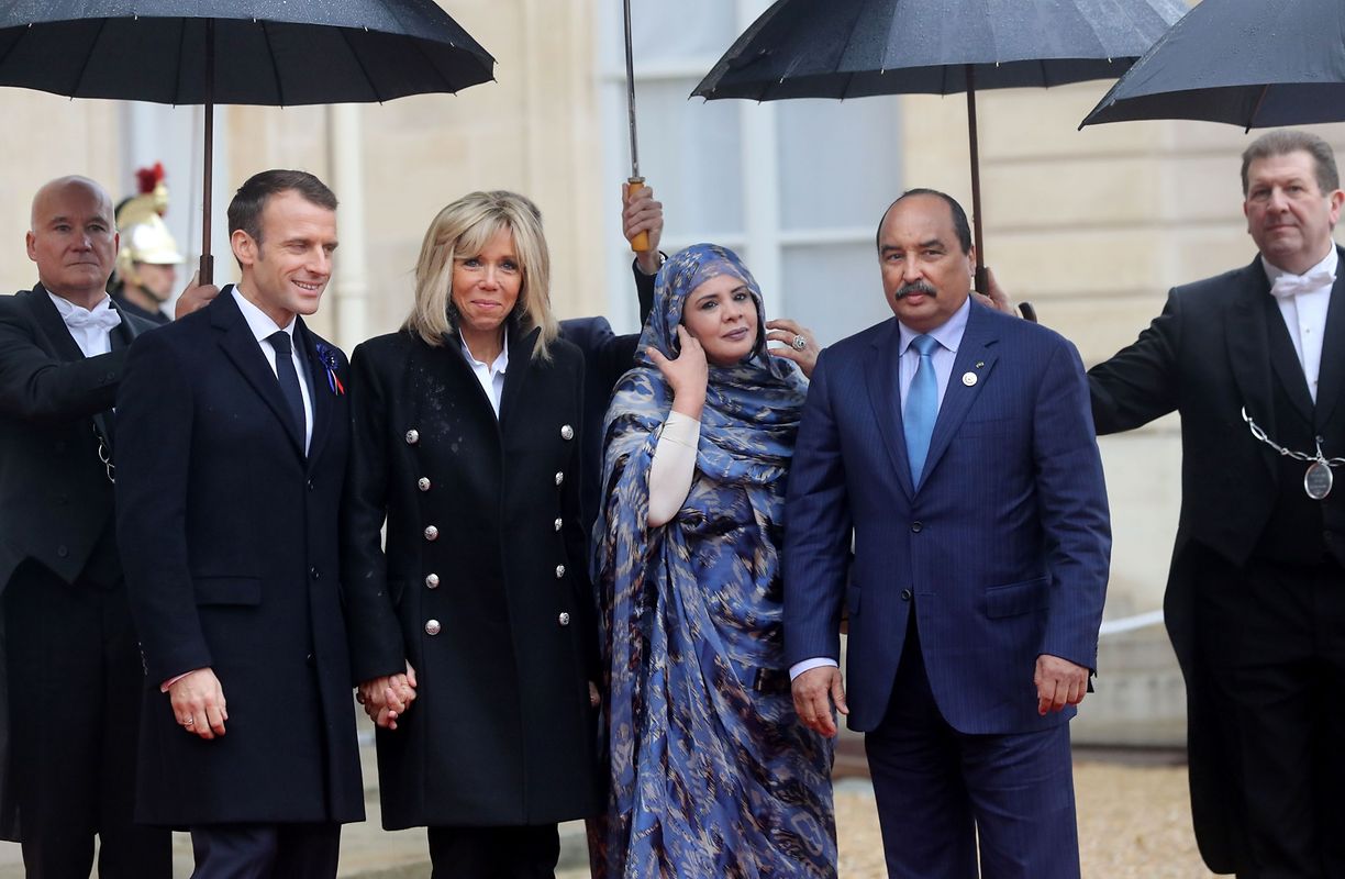French President Emmanuel Macron (L) and his wife Brigitte Macron welcome Mauritanian President Mohamed Ould Abdel Aziz and his wife Tekber Mint Melainine Ould Ahmed at the Elysee Palace in Paris on November 11, 2018 ahead of the start of commemorations marking the 100th anniversary of the 11 November 1918 armistice, ending World War I. (Photo by Jacques Demarthon / AFP)