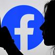 (FILES) In this illustration of the archive photo, a person looks at a smartphone with a Facebook application logo shown in the background, August 17, 2021, in Arlington, Virginia. .  - Facebook on October 8, 2021 said that some users had trouble accessing their services, a few days after a massive outage. 