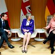 British Prime Minister Theresa May (C), German Chancellor Angela Merkel (R) and French President Emmanuel Macron (L) give a press conference following a meeting on the sidelines of the European Union leaders summit in Brussels, on March 22, 2018. / AFP PHOTO / POOL / Francois Lenoir