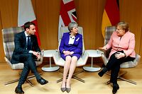 British Prime Minister Theresa May (C), German Chancellor Angela Merkel (R) and French President Emmanuel Macron (L) give a press conference following a meeting on the sidelines of the European Union leaders summit in Brussels, on March 22, 2018. / AFP PHOTO / POOL / Francois Lenoir