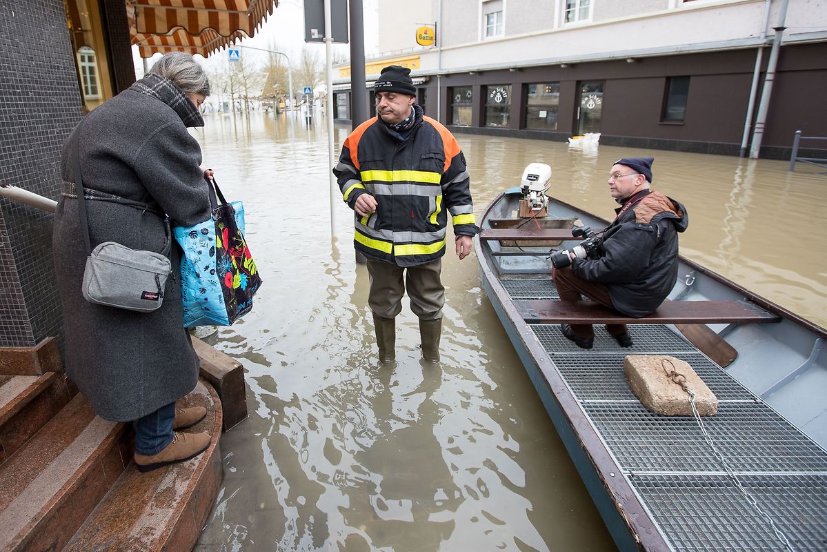 Die Feuerwehr hilft wo sie kann. Der Sohn dieser Dame ist eingeschlossen und hat nichts zu essen. Die Feuerwehr bringt ihm die Tüten voll mit Essen mit dem Boot. 