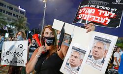 Israeli protesters lift placards during a demonstration in Rabin Square in the central coastal city of Tel Aviv, on July 11, 2020, to protest the government's abandonment of the country's self-employed and other sectors after forcing their businesses to close under COVID-19 regulations, according to the organizers. (Photo by Jack GUEZ / AFP)